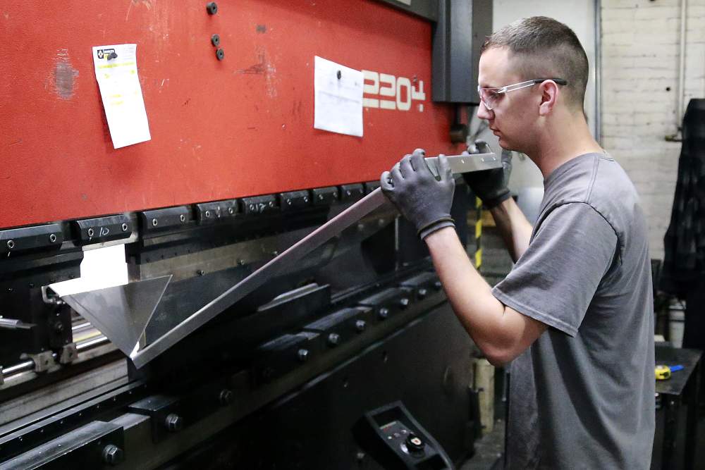 Kirby McGillivray,  an employee at Valco Industries in Springfield,  operates a break press Monday. A recent PEW research study showed Clark County lost a share of its middle class,  likely as manufacturing jobs were cut in half and were replaced by jobs that paid less. Bill Lackey\/Staff